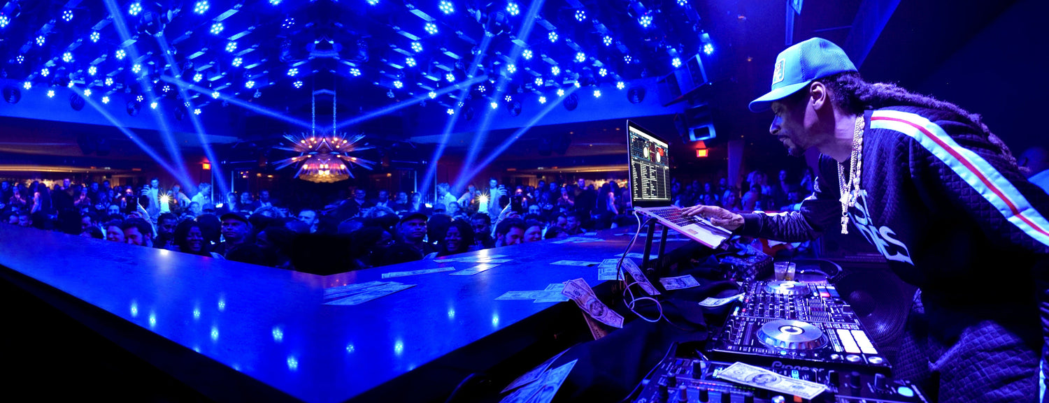 Snoop Dogg in front of a DJ set performing at a club