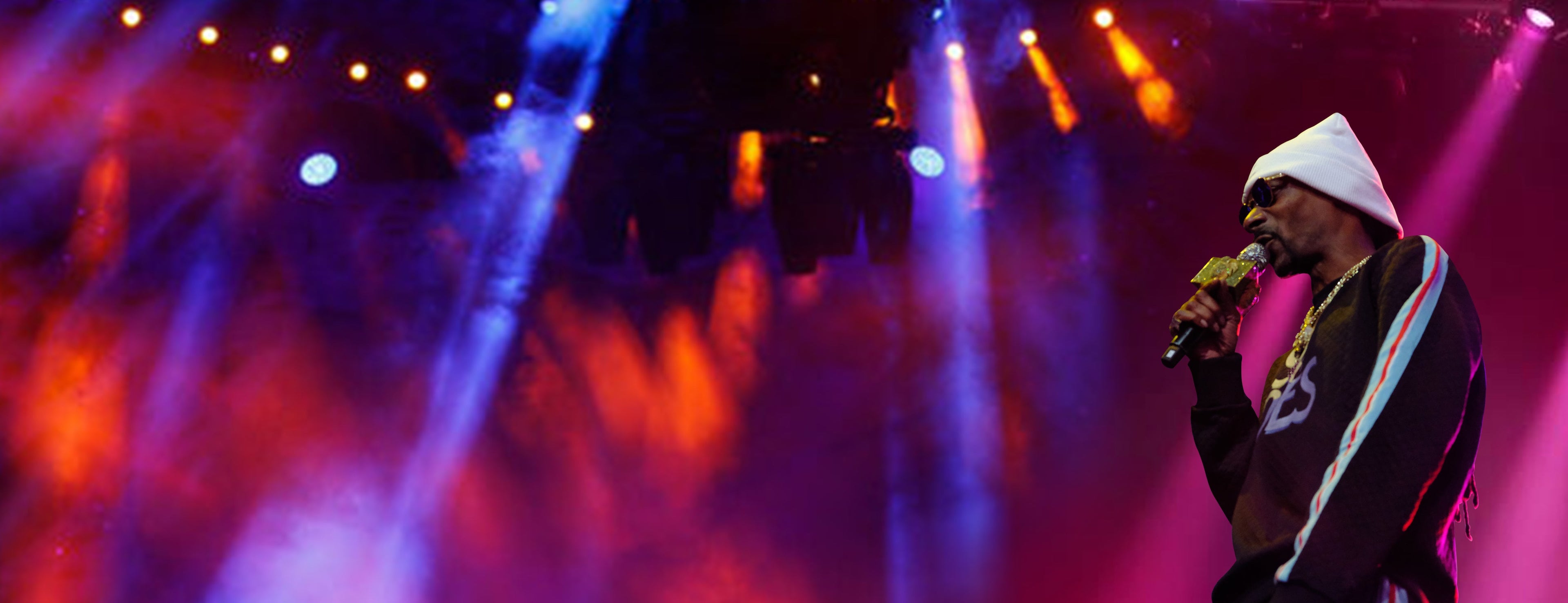 Snoop Dogg performing at a concert and holding a mic