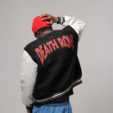 Person wearing a black and white varsity jacket with 'DEATH ROW' text on the back, red cap, and blue pants against a gray background.