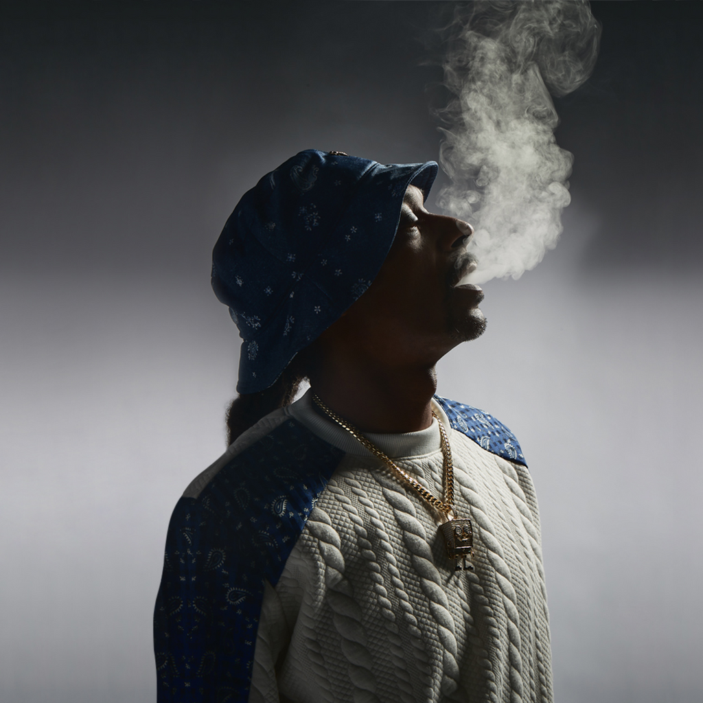 Snoop Dogg wearing a hat and breathing out smoke